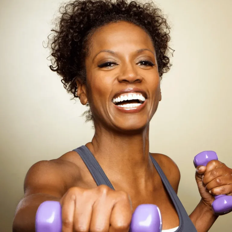 A woman doing fitness cardio with dumbbells smiling impersonating healthy fitness lifestyle